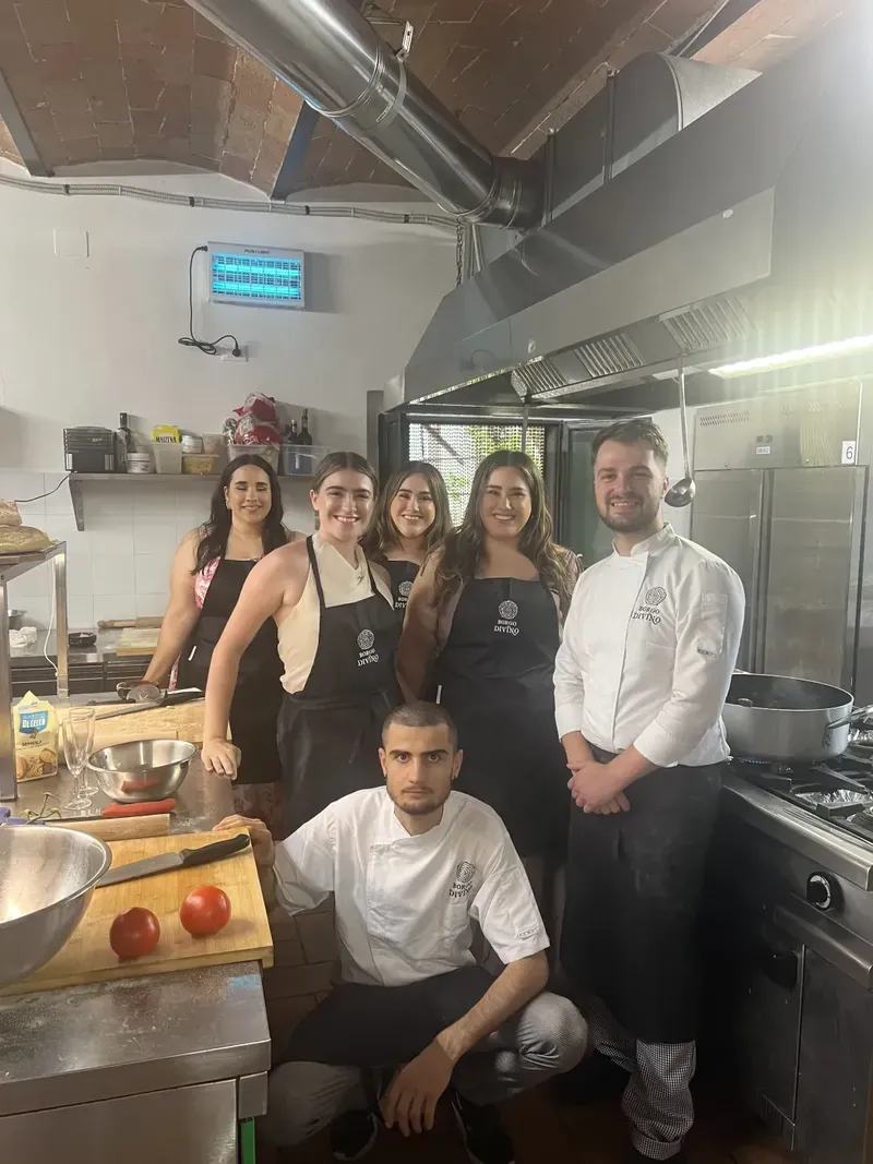 Guests cooking together in a working agriturismo kitchen in the Tuscan countryside