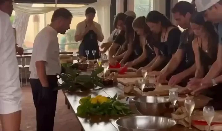 Guests rolling fresh pasta down the long table at a private Family Long-Table event
